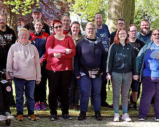 Eine Gruppe von Menschen steht lächelnd im Freien.