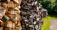 Holzscheite in einem Gitter, im Freien gelagert.
