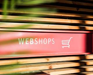 Ein rotes Schild mit der Aufschrift &#039;WEBSHOPS&#039; und einem Einkaufswagen-Symbol.