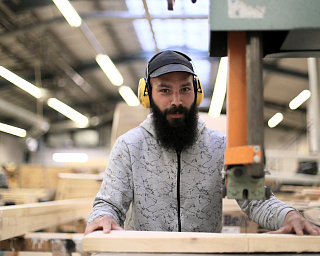 Ein Mann arbeitet mit Holz in einer Werkstatt.