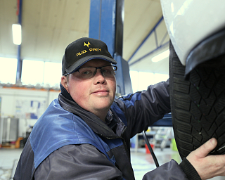 Ein Mechaniker überprüft einen Reifen in einer Werkstatt.