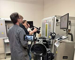 Kamerateam filmt Bedienung einer Maschine mit Monitor und Steuerung