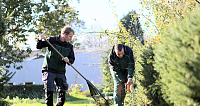 Zwei Gärtner pflegen Pflanzen in einem Garten.