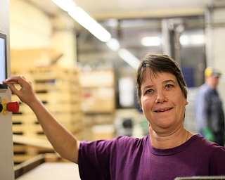 Eine Frau bedient eine Maschine in einer Fabrik.
