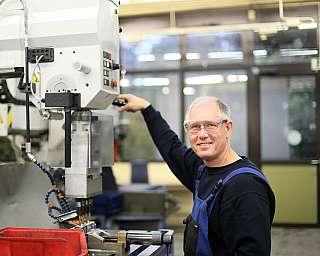 Ein Mann bedient eine Maschine in einer Werkstatt.
