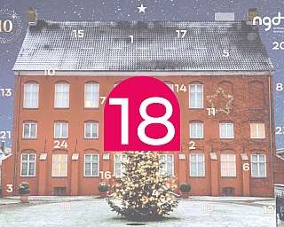 Ein rotes Gebäude mit Weihnachtsbaum und Schneefall.