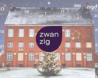 Ein rotes Gebäude mit Weihnachtsbaum und Schnee im Hof.