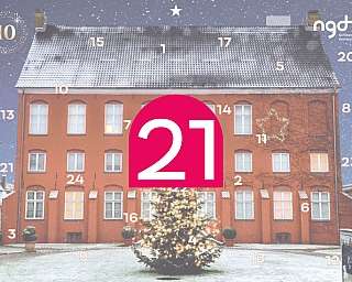 Ein rotes Haus mit Weihnachtsbaum und Schnee im Hintergrund.