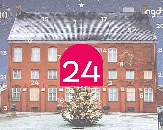 Ein rotes Gebäude mit Weihnachtsbaum und Schneefall.