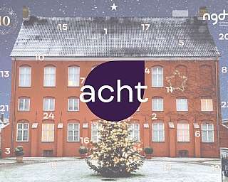 Ein rotes Gebäude mit Weihnachtsbaum und Schnee im Hof.