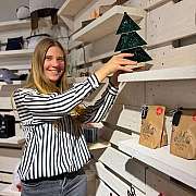 Eine Frau stellt einen Weihnachtsbaum auf ein Regal.