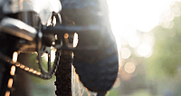 Nahaufnahme eines Mountainbike-Reifens auf einem Weg im Sonnenlicht