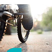 Nahaufnahme eines Mountainbike-Reifens auf einem Weg im Sonnenlicht