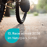 Ausschnitt von einem Fahrrad, auf dem eine Person fährt, die Schuhe sind zu sehen
