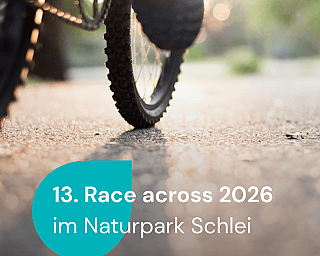 Race across 2026 Ausschnitt von einem Fahrrad mit einer Person drauf.