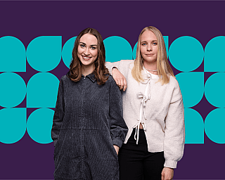 Zwei Frauen vor dunkelviolettem Hintergrund mit blauem geometrischem Muster