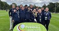Gruppenfoto unserer Fussball-Mannschaft, die vor einem Schild steht. Auf dem Schild steht: Deutsche Meisterschaft Fussball, der Werkstätten für behinderte Menschen, DFB-Stiftung Sepp Herberger, Deutscher Behindertensportverband e.V. und BAG WfbM